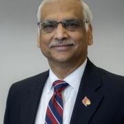 Headshot of Dr. Bhatnagar against gray background