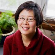 Headshot of Ming Kuo in front of potted plant