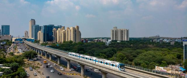 train over street with urban landscape in the background