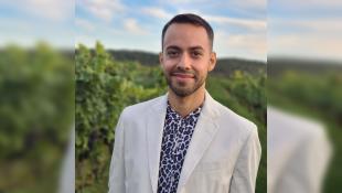 Daniel Carrión standing in front of greens