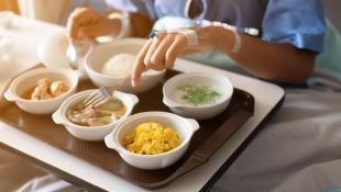 Hospital food being eaten by person in blue gown