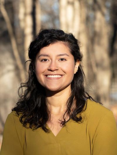 headshot of Cindy Cifuentes in yellow blouse with woods in the background