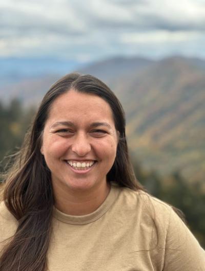 headshot of Hannah Vase in a tan shirt with mountains in the background