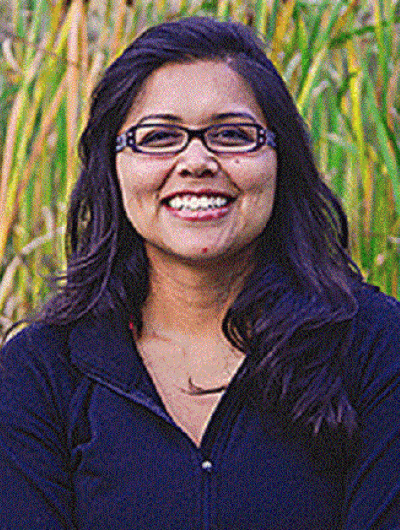 Headshot of Esther Rojas-Garcia against the backdrop of a lush green field.