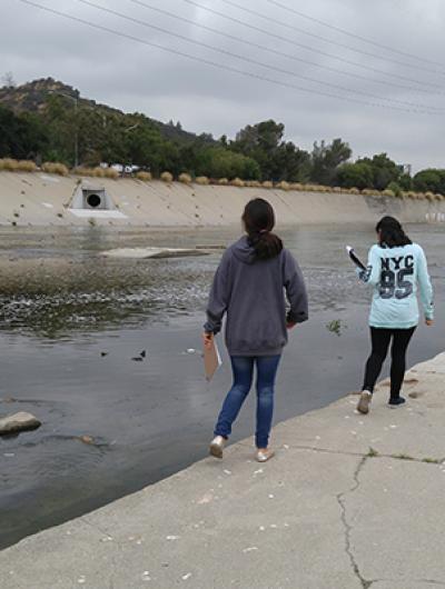 Photo of youth exploring an urban water pass. 