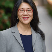 Headshot of Karen Seto in a gray blazer with a pathway in the background