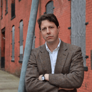 Headshot of Elihu Rubin with red brick building in the background