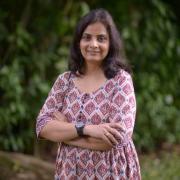 Portrait of Shalini Dhyani in pink dress with foliage in the background