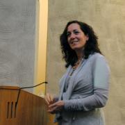 Jeannette Ickovics in a gray cardigan standing at a podium