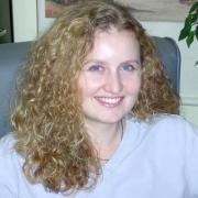 Headshot of Michelle Bell sitting in armchair