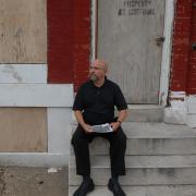 Steward Pickett sitting on front steps of red building