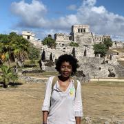 Cassandra Johnson Gaither with palm trees and stone structures in the background