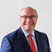 Headshot of Jeff Diehl in dark suite and red tie against white background