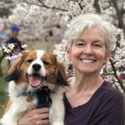 Headshot of Ko Barrett with dog with cherry tree in background