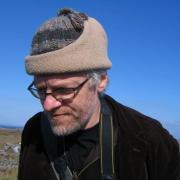Headshot of Liam Heneghan in woolly hat against blue sky