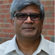 Headshot of Brian Pillay against red brick background