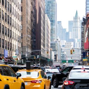 NYC traffic with yellow taxis and skyscrapers in the background